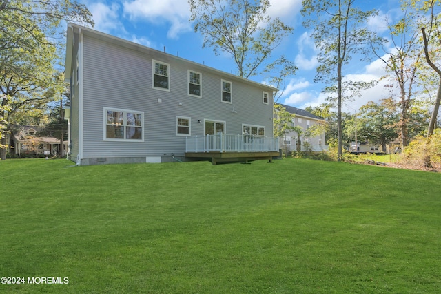 rear view of property featuring a deck, a yard, and crawl space