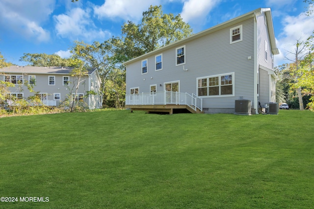 back of house featuring a deck, central AC unit, and a lawn