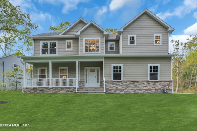 view of front facade featuring covered porch, stone siding, and a front lawn