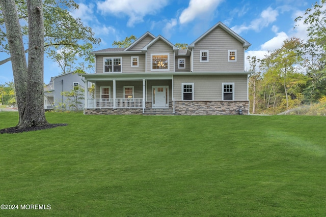 view of front facade with stone siding, a front yard, and covered porch