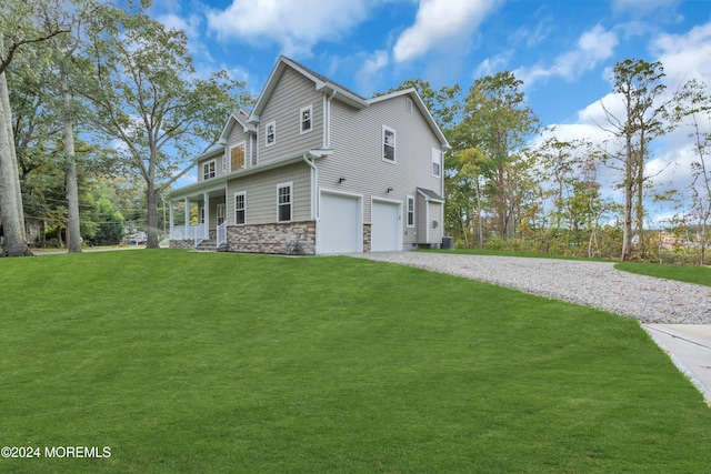 view of side of home with a yard, a porch, an attached garage, stone siding, and driveway