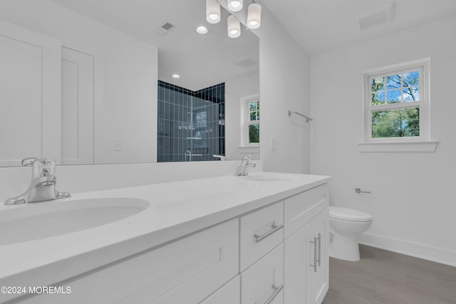 bathroom with toilet, a stall shower, visible vents, and a sink