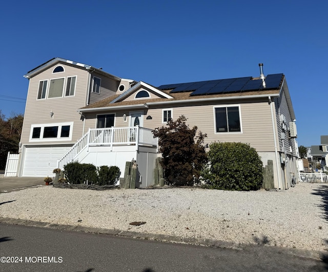 view of front facade featuring a garage and solar panels