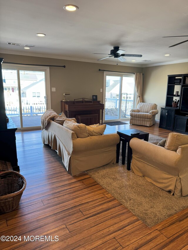 living room with hardwood / wood-style flooring, crown molding, and ceiling fan