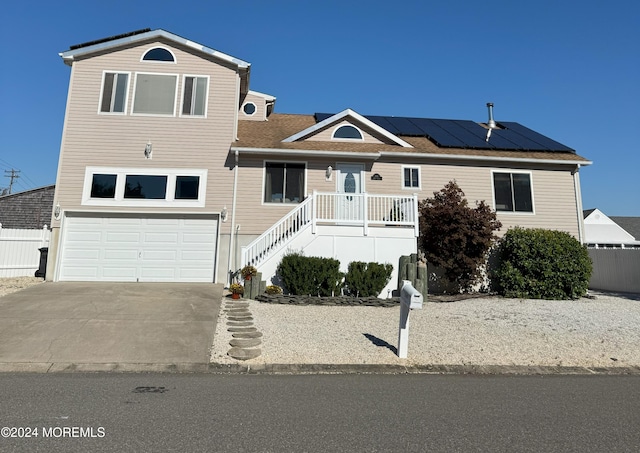 view of front of property featuring a garage and solar panels