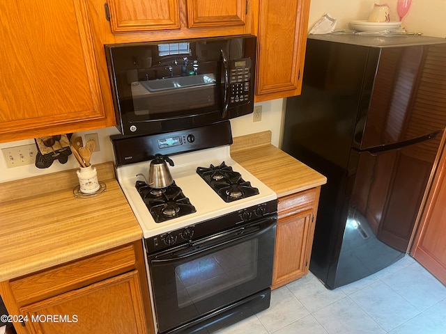 kitchen with black appliances and light tile patterned floors