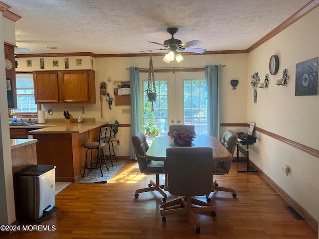 dining space featuring crown molding, ceiling fan, hardwood / wood-style floors, and a textured ceiling