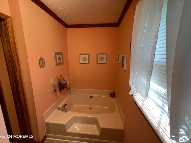 bathroom featuring ornamental molding, a bathing tub, and a textured ceiling