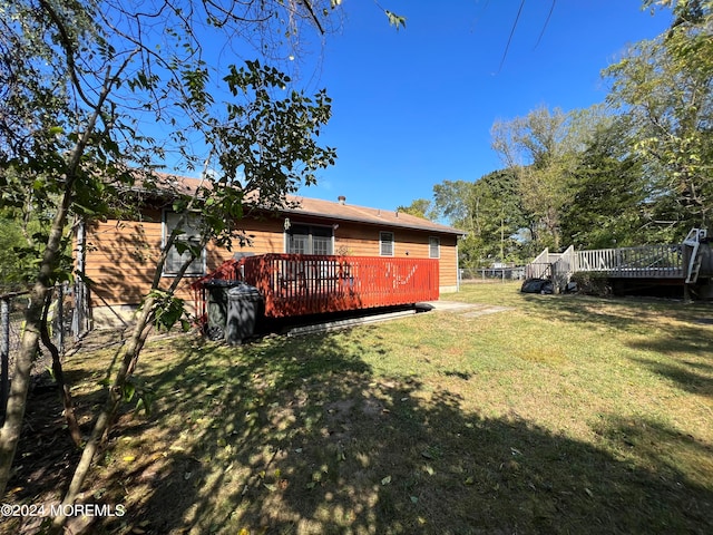 rear view of house featuring a yard and a wooden deck