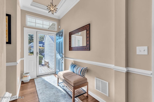 foyer entrance with crown molding and hardwood / wood-style floors