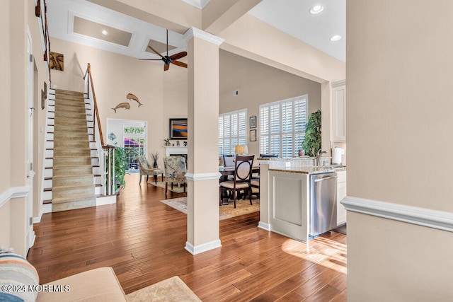 entrance foyer with beam ceiling, hardwood / wood-style flooring, a high ceiling, and ceiling fan