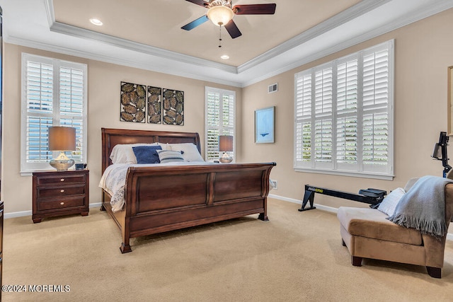 carpeted bedroom featuring crown molding, a tray ceiling, and ceiling fan