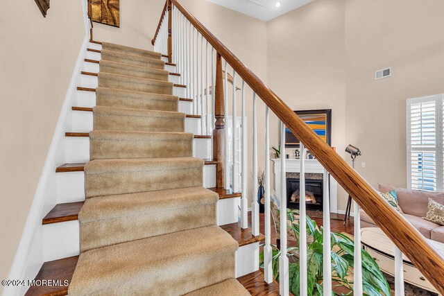 staircase featuring hardwood / wood-style floors and a high ceiling