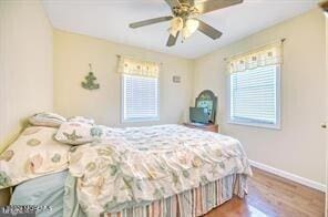 bedroom featuring hardwood / wood-style flooring, multiple windows, and ceiling fan