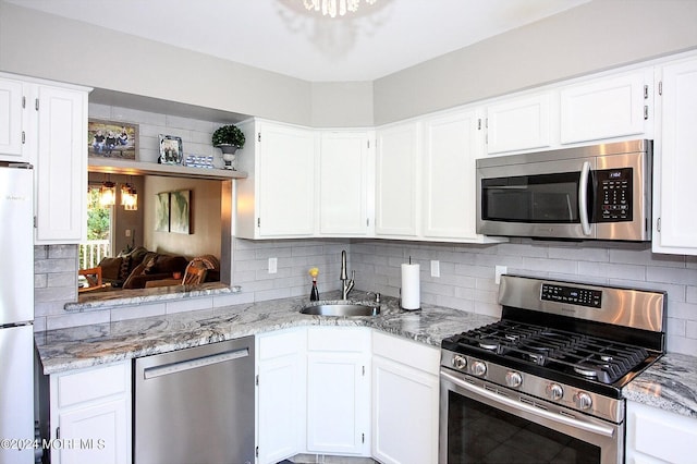 kitchen with stainless steel appliances, sink, and white cabinetry