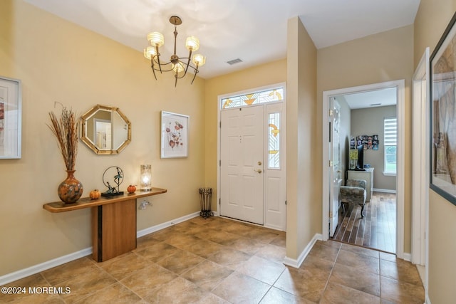 entryway featuring a wealth of natural light and a chandelier