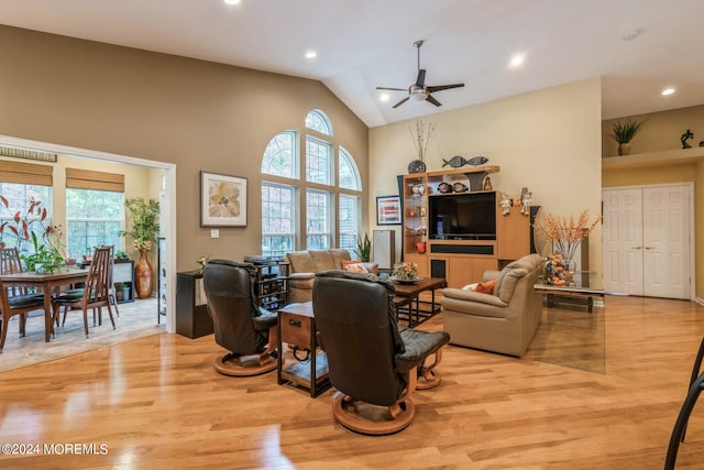 living room with high vaulted ceiling, light wood-type flooring, and ceiling fan