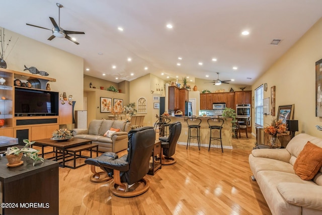 living room with lofted ceiling, light hardwood / wood-style floors, and ceiling fan