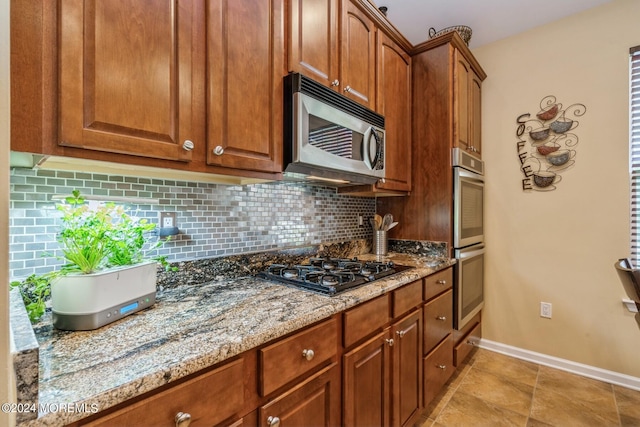 kitchen featuring stainless steel appliances, tasteful backsplash, and stone countertops