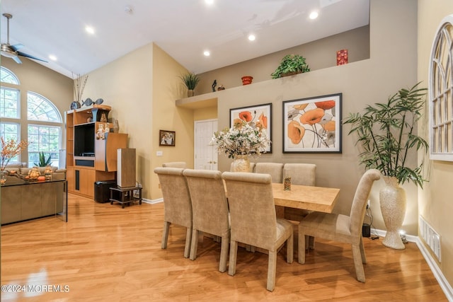 dining room featuring high vaulted ceiling, light hardwood / wood-style flooring, and ceiling fan