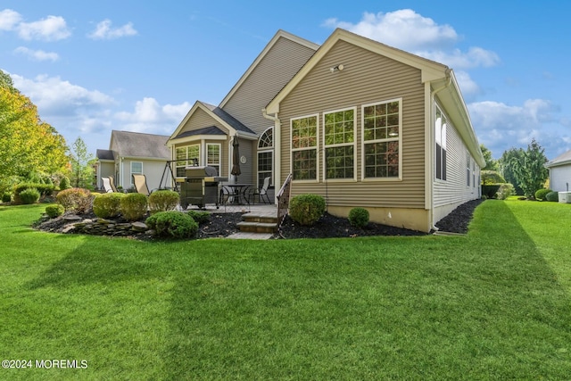 rear view of property with a yard and a patio area