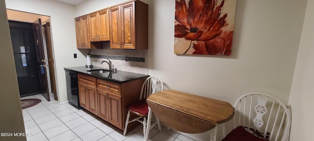 kitchen with backsplash, black dishwasher, sink, and light tile patterned floors