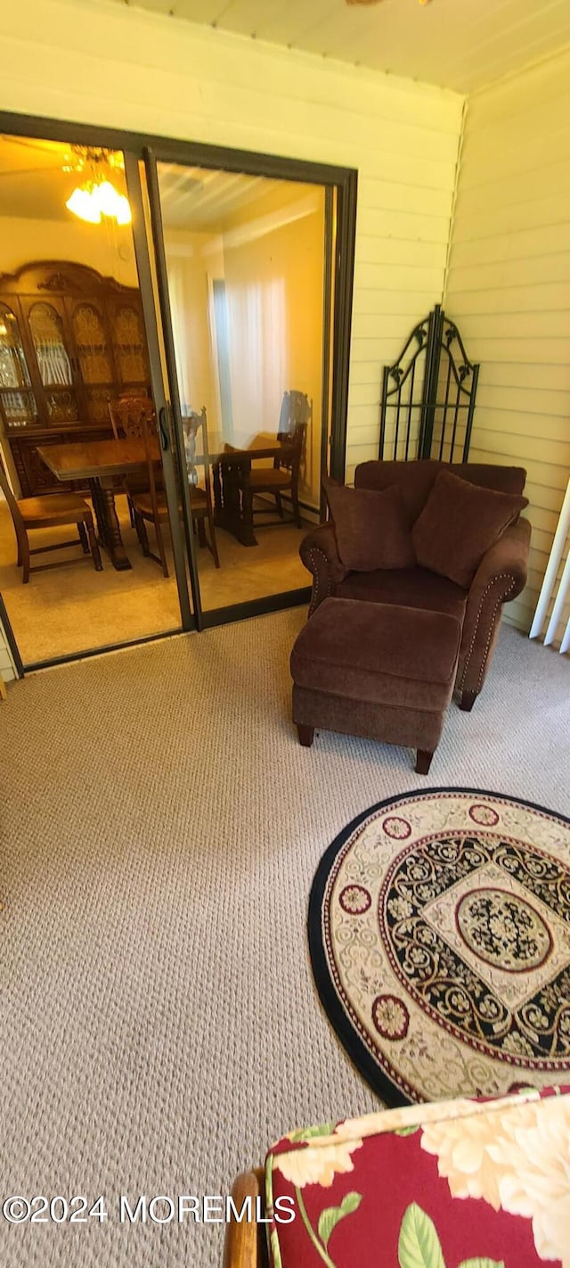 living room with wood walls and carpet flooring