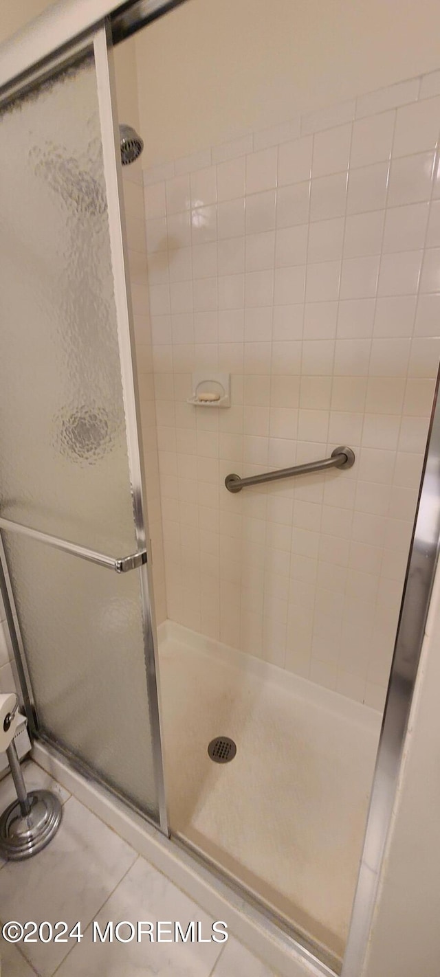 bathroom featuring tile patterned flooring and a shower with door