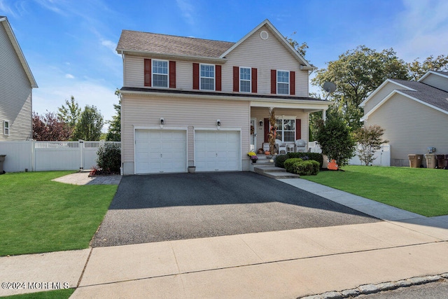 view of front of house featuring a garage, a porch, and a front lawn