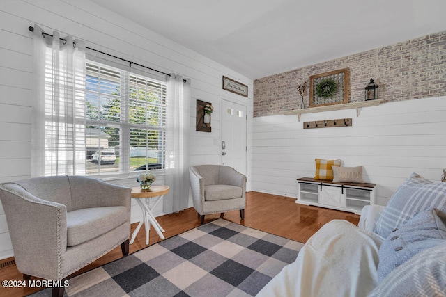 living room featuring wood-type flooring and wooden walls