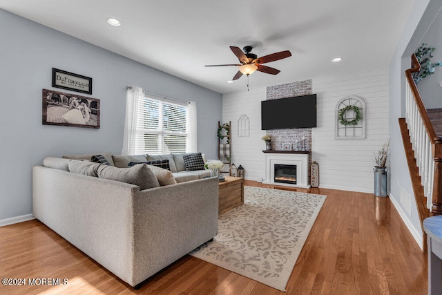 living room with hardwood / wood-style flooring, a fireplace, and ceiling fan