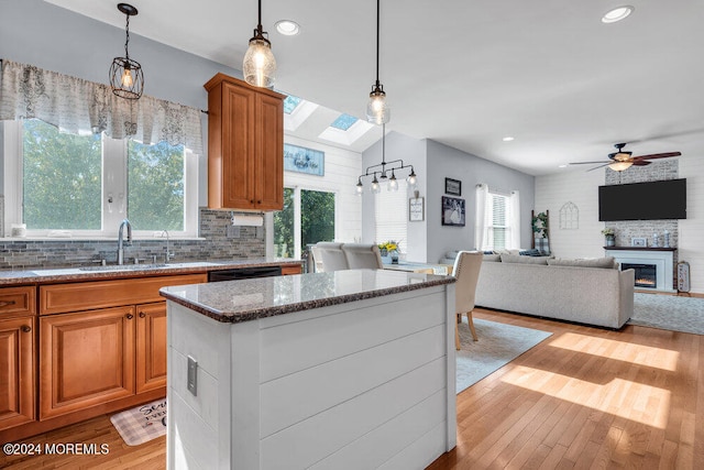 kitchen featuring pendant lighting, a skylight, light hardwood / wood-style flooring, and ceiling fan