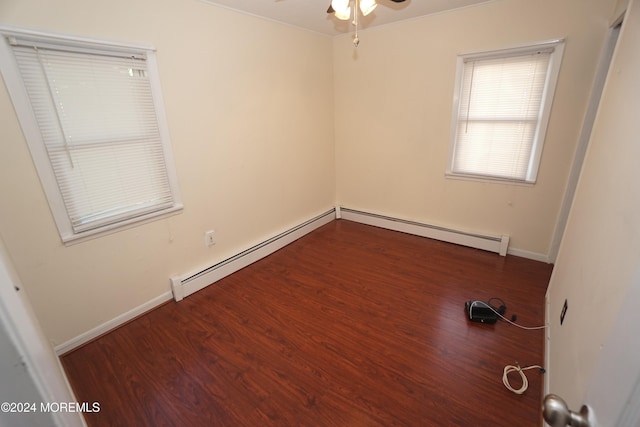 spare room featuring dark wood-type flooring, ceiling fan, and a baseboard radiator