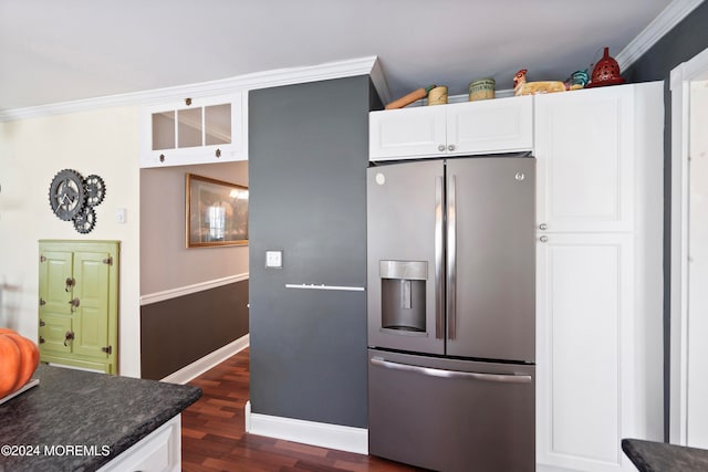 kitchen with dark stone counters, dark wood-type flooring, ornamental molding, stainless steel fridge with ice dispenser, and white cabinetry