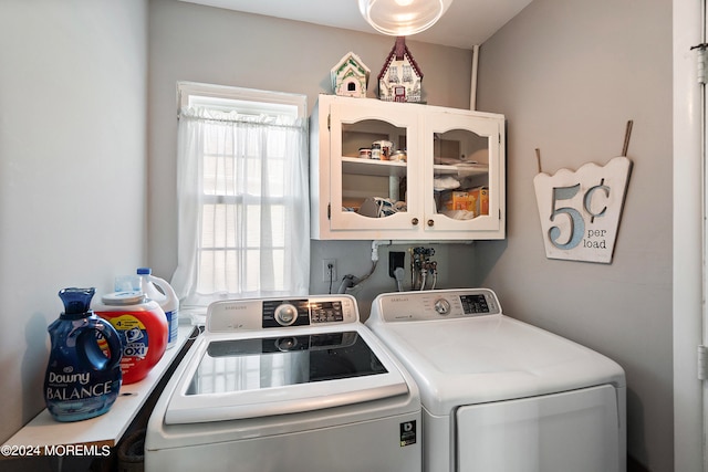 laundry area featuring washer and clothes dryer and cabinets