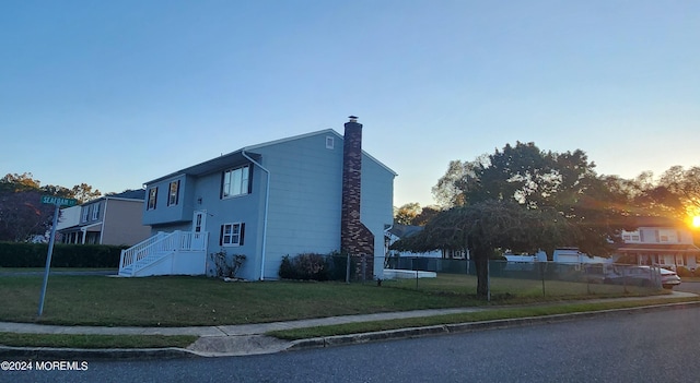 property exterior at dusk with a lawn