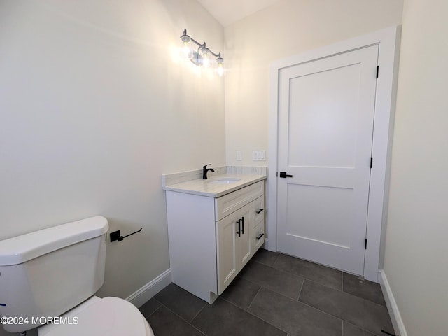 bathroom featuring toilet, vanity, and tile patterned floors