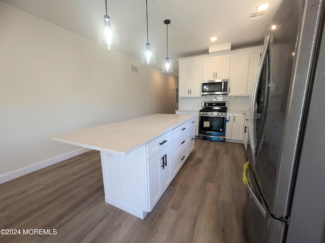 kitchen with white cabinetry, stainless steel appliances, dark wood-type flooring, pendant lighting, and a center island