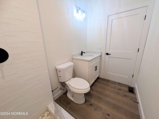 bathroom featuring vanity, hardwood / wood-style floors, and toilet