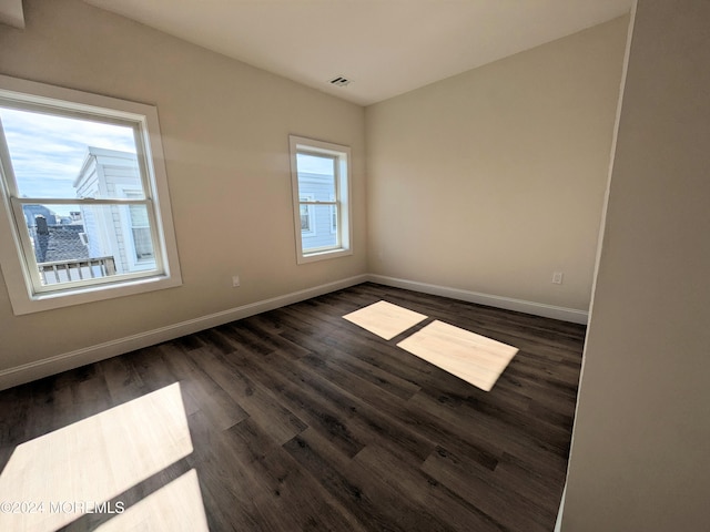 unfurnished room with dark hardwood / wood-style floors