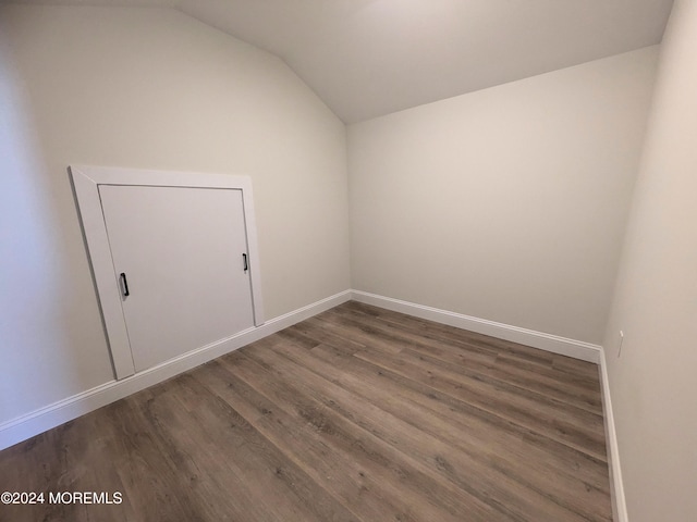 spare room with lofted ceiling and dark hardwood / wood-style flooring