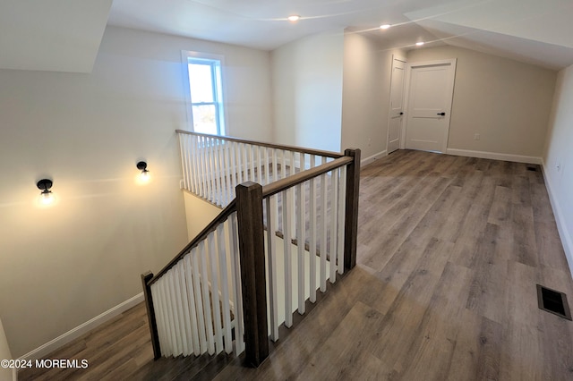 stairs with hardwood / wood-style flooring and vaulted ceiling