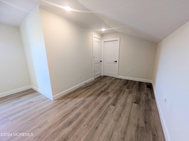 bonus room with hardwood / wood-style flooring and vaulted ceiling