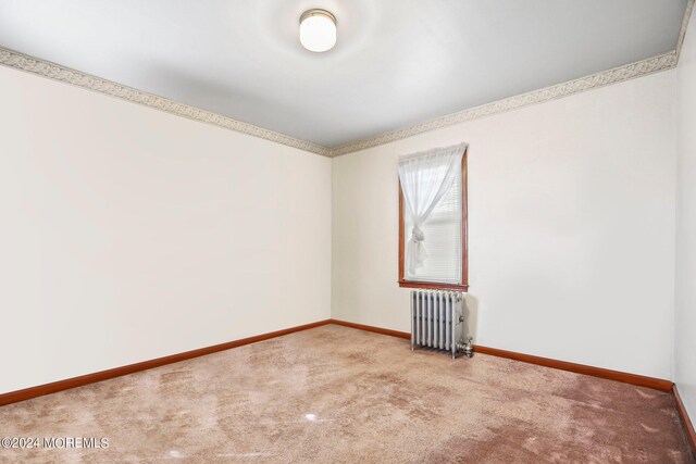 empty room with radiator heating unit and carpet