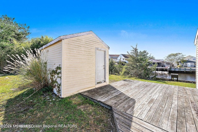 wooden terrace with a shed and a water view