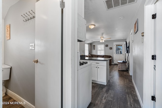 kitchen featuring white range, white cabinetry, dark hardwood / wood-style floors, and ceiling fan