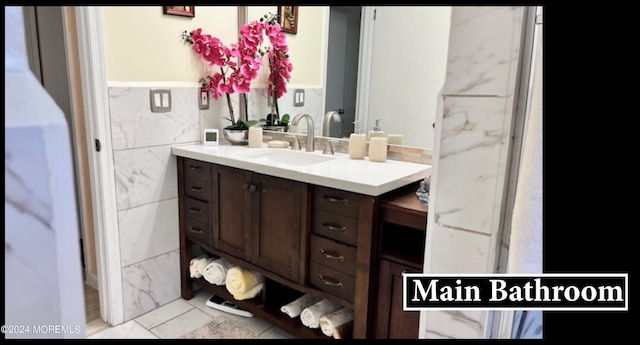 bathroom with tile walls, vanity, and tile patterned flooring