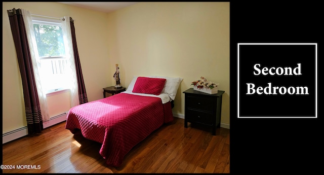 bedroom featuring a baseboard radiator and dark hardwood / wood-style flooring