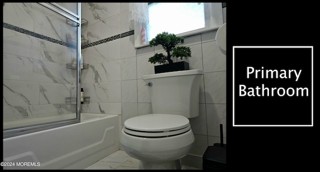 bathroom featuring tile walls, tiled shower / bath combo, and toilet