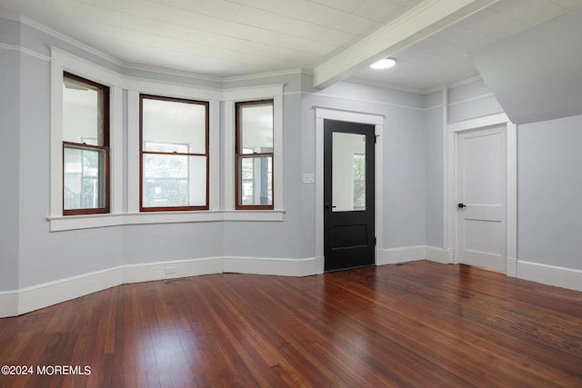 entrance foyer featuring ornamental molding, a healthy amount of sunlight, beam ceiling, and dark hardwood / wood-style floors